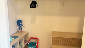 A child's room with a wooden dresser, a shelf with toys, and a red toy car. - Spacious 3BR House in Frisco - Minutes from Top Event Attractions (Frisco)