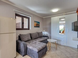 A modern living space with a sofa, a small table, a TV, and a wardrobe. - Apartment Duema by Interhome (Opatija/Pobri)