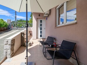 A balcony with outdoor seating, a door, and a window. - Apartment Duema by Interhome (Opatija/Pobri)