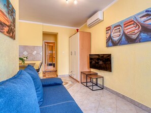 Un soggiorno moderno con un divano, una TV e opere d'arte alle pareti.