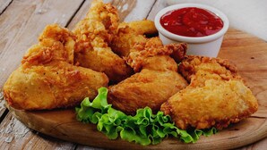 Fried chicken pieces on a wooden board with lettuce and a side of ketchup. - Townhouse Bairhana Road Prayagraj (Prayagraj)