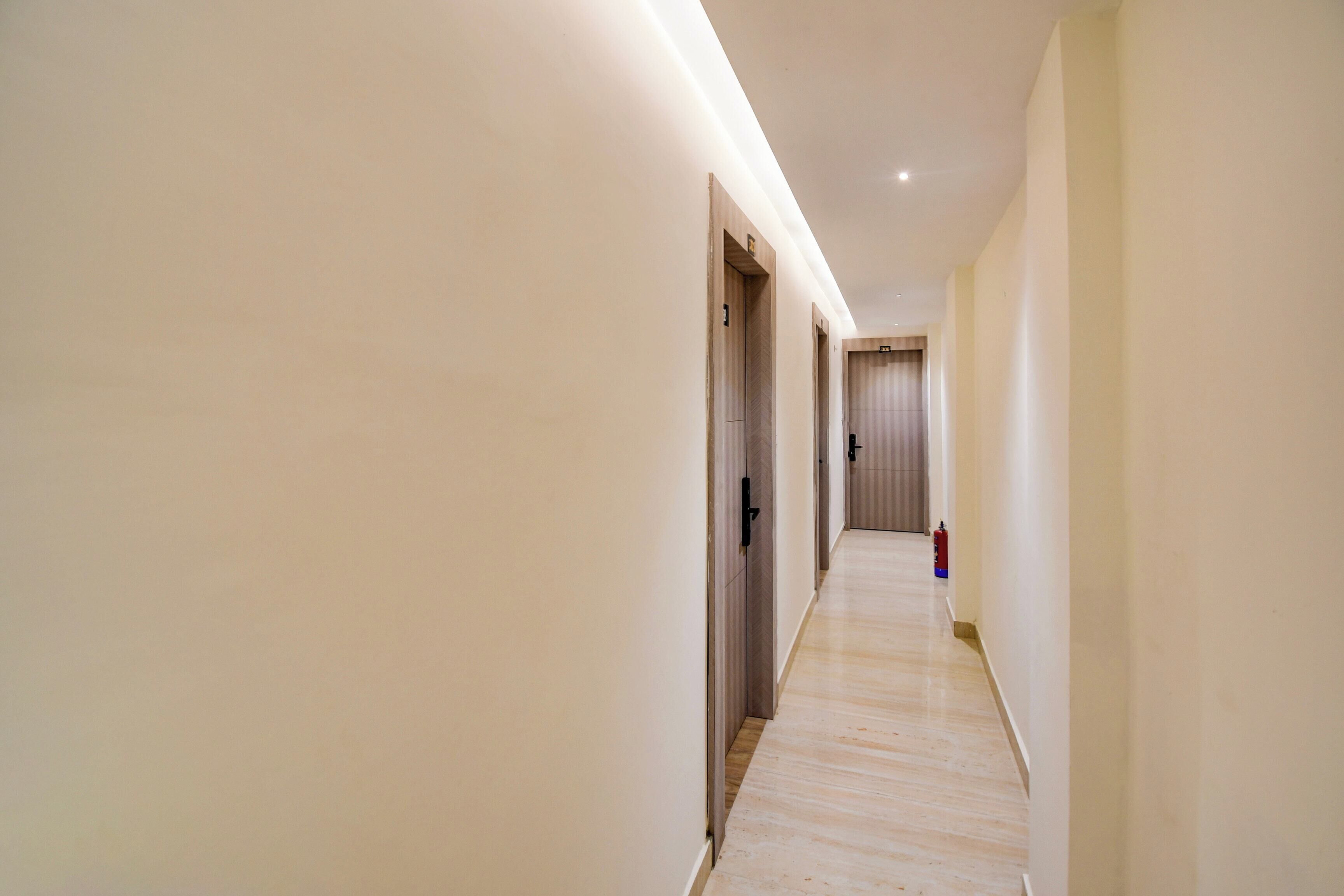 A long, narrow hallway with wooden flooring and light-colored walls.