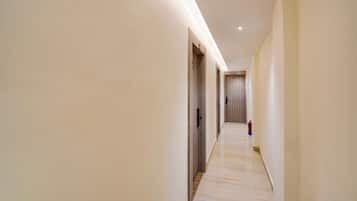 A long, narrow hallway with wooden flooring and light-colored walls.