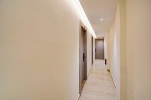 A long, narrow hallway with wooden flooring and light-colored walls. - Townhouse Bairhana Road Prayagraj (Prayagraj)