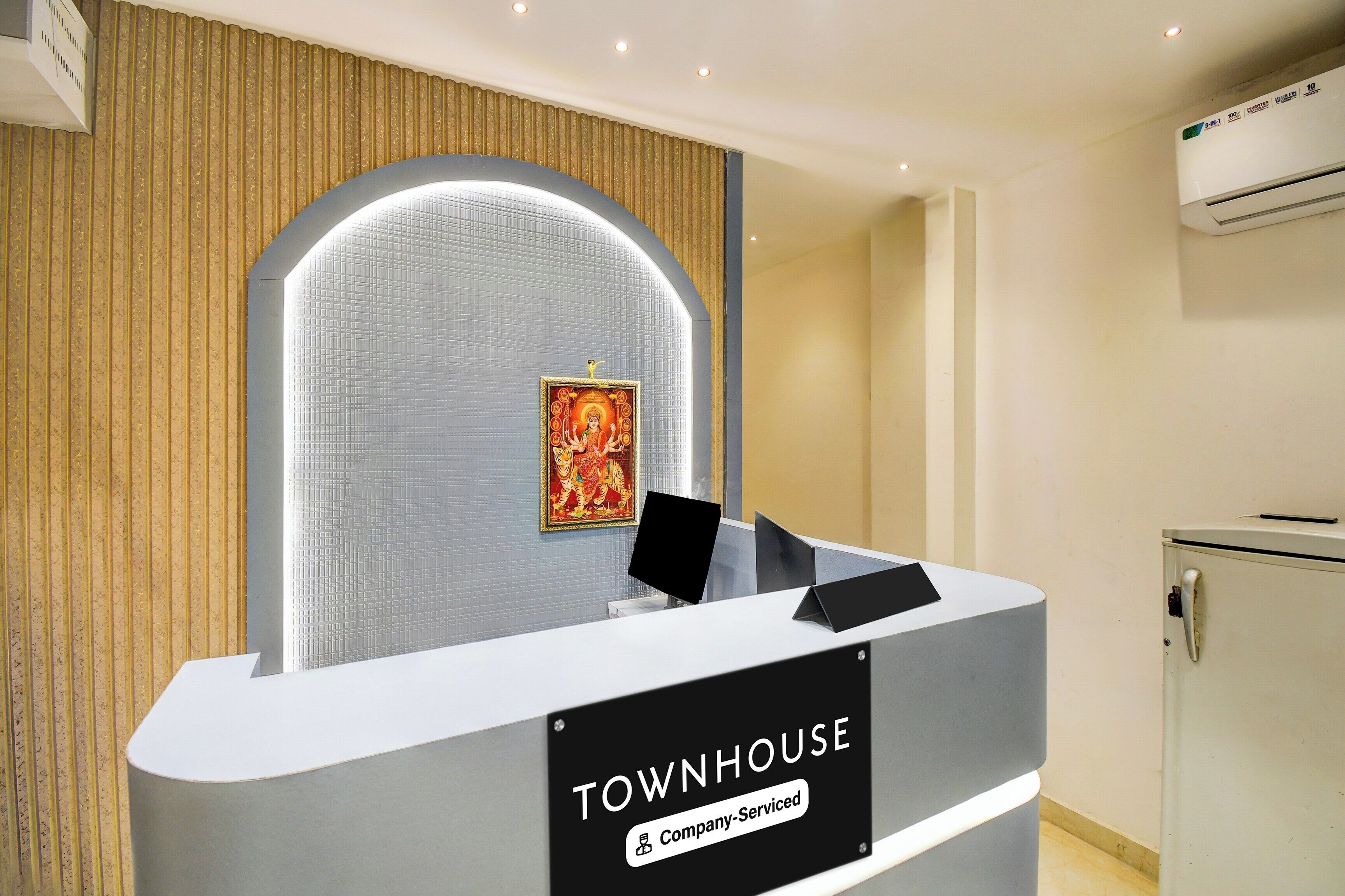 A reception desk with a sign reading 'TOWNHOUSE Company-Serviced.'