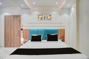 Una camera da letto moderna con un letto grande, una porta in legno e un lampadario a parete.