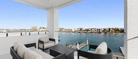 Ein moderner Balkon im Freien mit Blick auf eine Marina und die Skyline der Stadt.