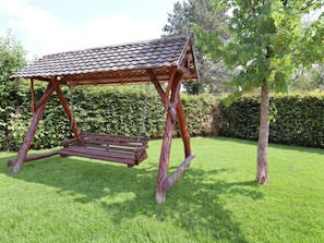 Eine Holzwentilgruppe mit einem Ziegeldach in einem grünen Garten.