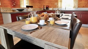 Un interno in legno con una colazione preparata, inclusi croissant, succo di frutta e caffè.