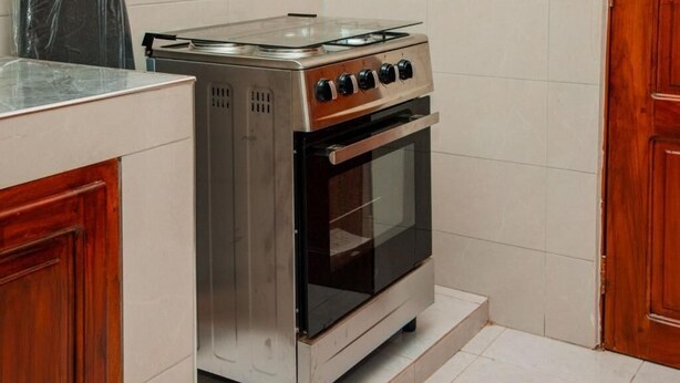 Une cuisine équipée d’une cuisinière, d’un four et d’une armoire en acier inoxydable, ainsi que d’un meuble en bois.