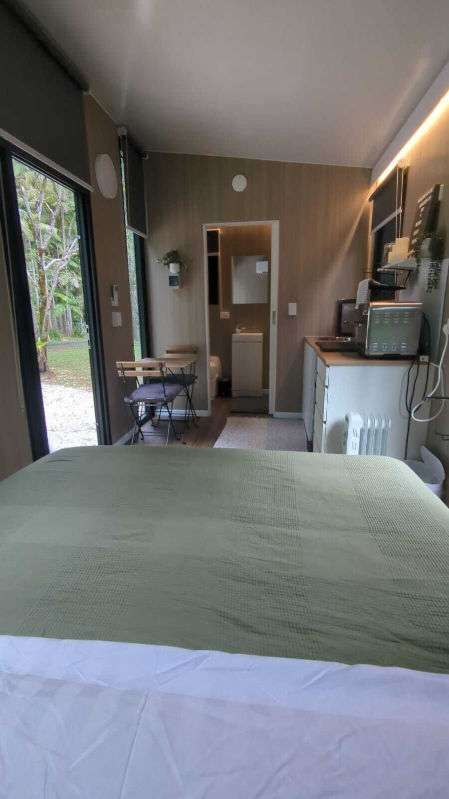 Een slaapkamer met een bed, een bureau, een stoel, een radiator en een raam.