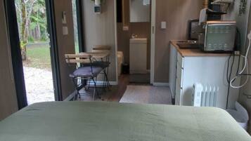 Een slaapkamer met een bed, een bureau, een stoel, een radiator en een raam.