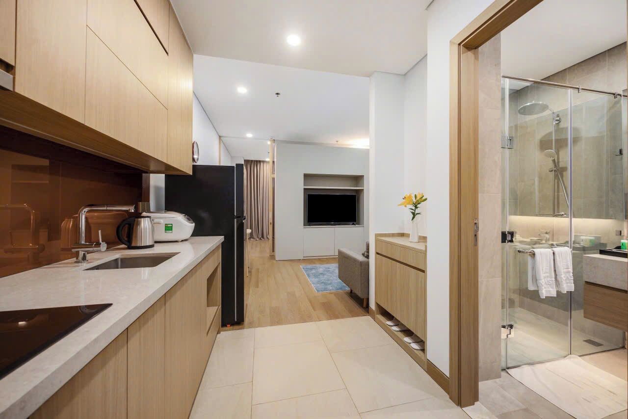 A modern kitchen with a built-in oven, a coffee maker, and a refrigerator.