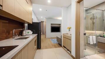 A modern kitchen with a built-in oven, a coffee maker, and a refrigerator.