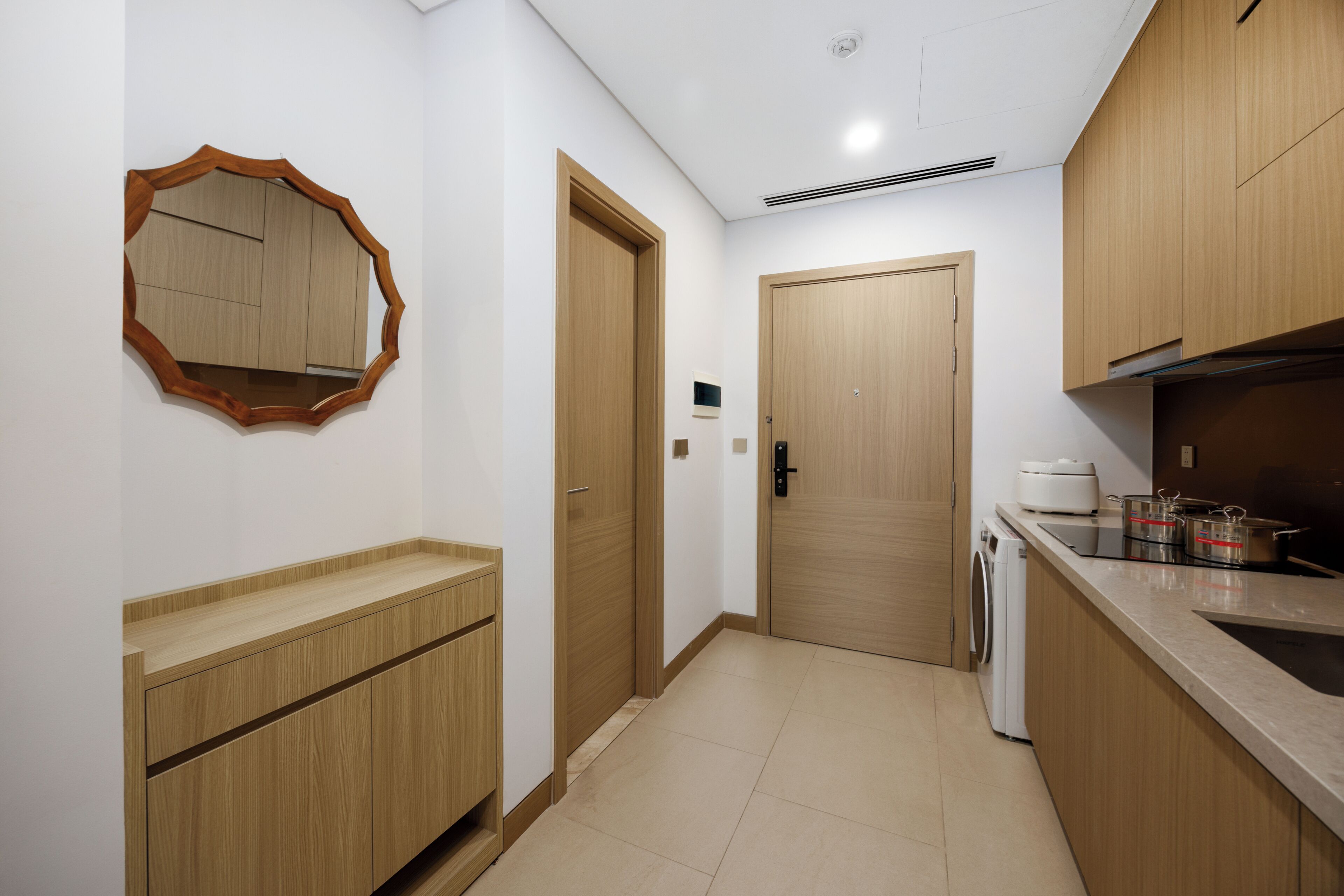 A modern kitchen with wooden cabinets, a built-in oven, and a sink.