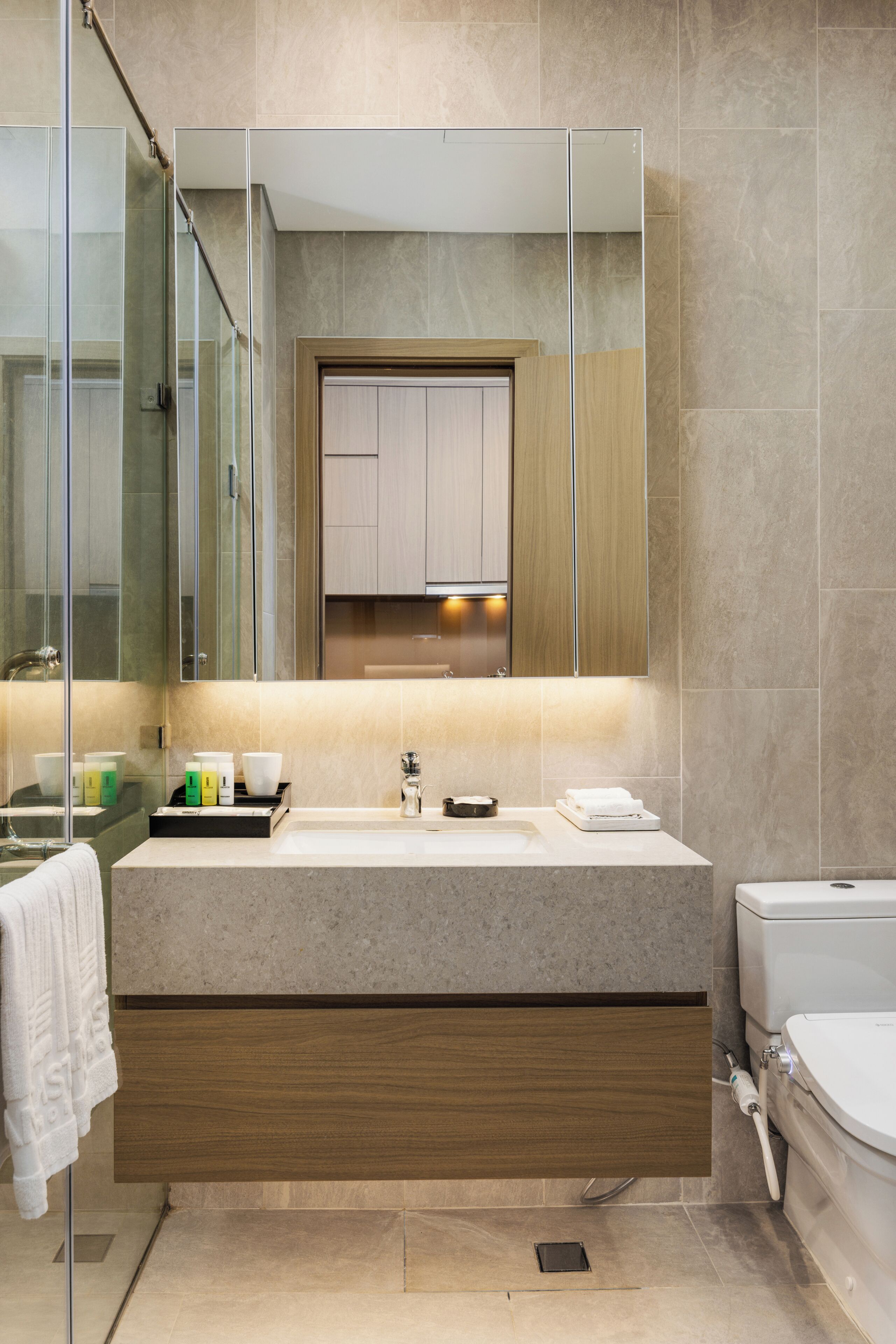 A modern bathroom with a glass shower enclosure, a vanity with a sink, and a toilet.