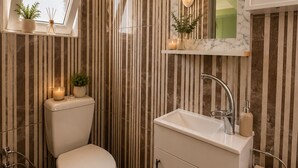 A bathroom with a toilet, sink, and a window above the toilet. - Empati Otel (Ayvalık)