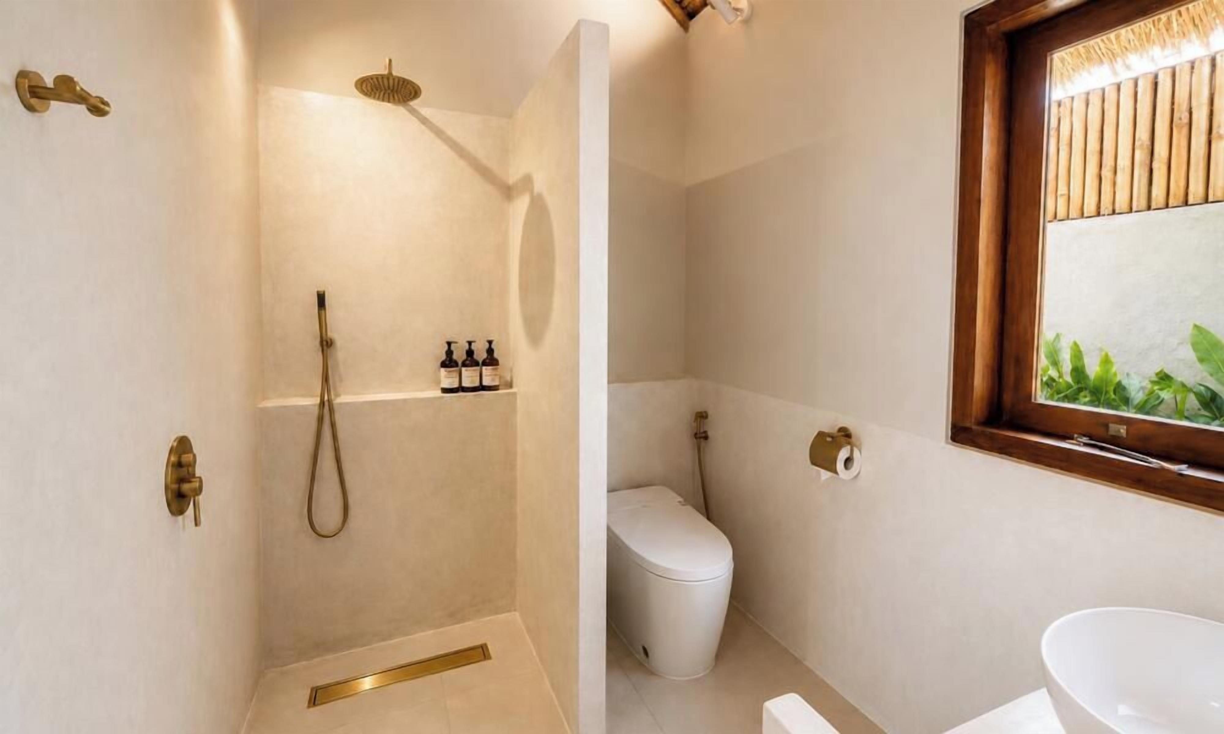 Ein Badezimmer mit Dusche, Toilette und Waschbecken.