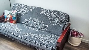 Ein Sofa mit floralem Muster, eine Lampe und ein Wanddekor.