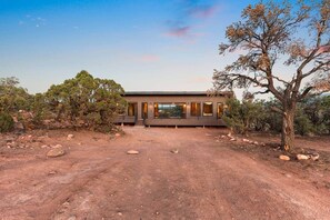 A modern house with a large open porch, surrounded by natural bushland. - The Moki House (with hot tub) (Wayne County)