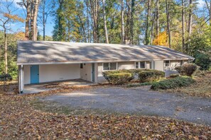 A single-story house with a garage, surrounded by trees and a driveway. - Corporate Comfort | Stylish 3BR Extended Stay (Decatur)