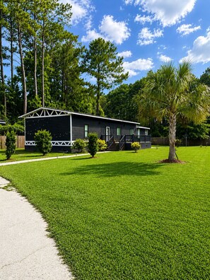 A single-story building with a dark exterior, a front porch, and a well-maintained lawn.