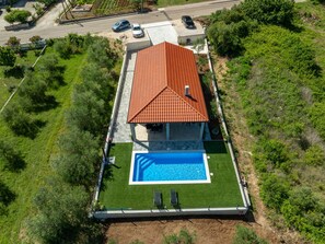 A residential property with a swimming pool, a red-tiled roof, and a well-maintained lawn. - Holiday Home Bonato with pool by Interhome (Krneza)