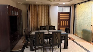 A dining area with a table and chairs, a television, and a decorative door.
