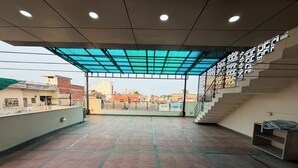 An indoor area with a tiled floor, a staircase, and a view of the cityscape.