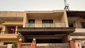 A two-story residential building with a gated entrance, a balcony on the upper floor, and a satellite dish on the roof. - Rameshawram Sukoon Mansion (Varanasi)