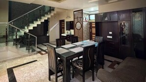 A modern interior with a dining area, kitchen, and staircase. - Rameshawram Sukoon Mansion (Varanasi)