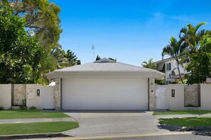 A modern two-story house with a garage, surrounded by a well-maintained lawn and palm trees. - Riviera Rd Miami - 2/29 (2B/1B) (Gold Coast)