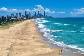 Une plage avec la silhouette d’une ville en arrière-plan.