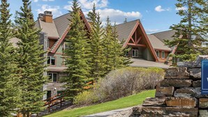 A large, multi-story building with a stone facade and a prominent sign for Canmore-Banff Resort. -  Spacious 2-bedroom condo in Magical Canmore with fitness room and AC (Canmore)