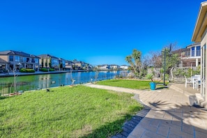 A residential area with a river, houses, and a paved walkway.