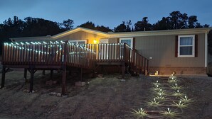 Una casa de un piso con una terraza de madera y un pequeño porche.