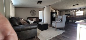 A living room with a leather sofa, a coffee table, and a decorative wall piece. - Beautiful getaway with amazing view (Alto)