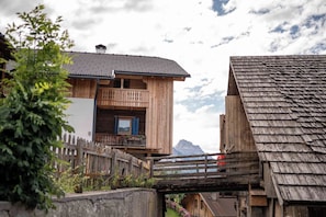 A wooden chalet with a balcony, a mountain view, and a traditional design.