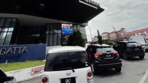 Un edificio moderno con fachada de vidrio y un cartel que dice 'KOTISQUAR'.