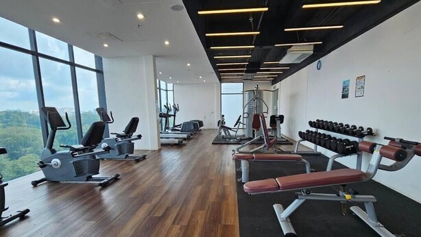 A gym with cardio machines, weight benches, and dumbbells. - Kozi Square Kozi 9A (Kuching)