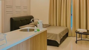 A hotel room with a kitchenette, a bed, a bedside table, and a window with curtains. - Kozi Square Kozi 9A (Kuching)