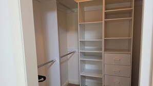 Un dressing avec des étagères ouvertes et un ensemble de tiroirs.