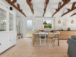 A spacious kitchen with wooden beams, a dining area with a table and chairs, and a view through a window. - "Antonie" - 350m from the sea by Interhome (Vejby)