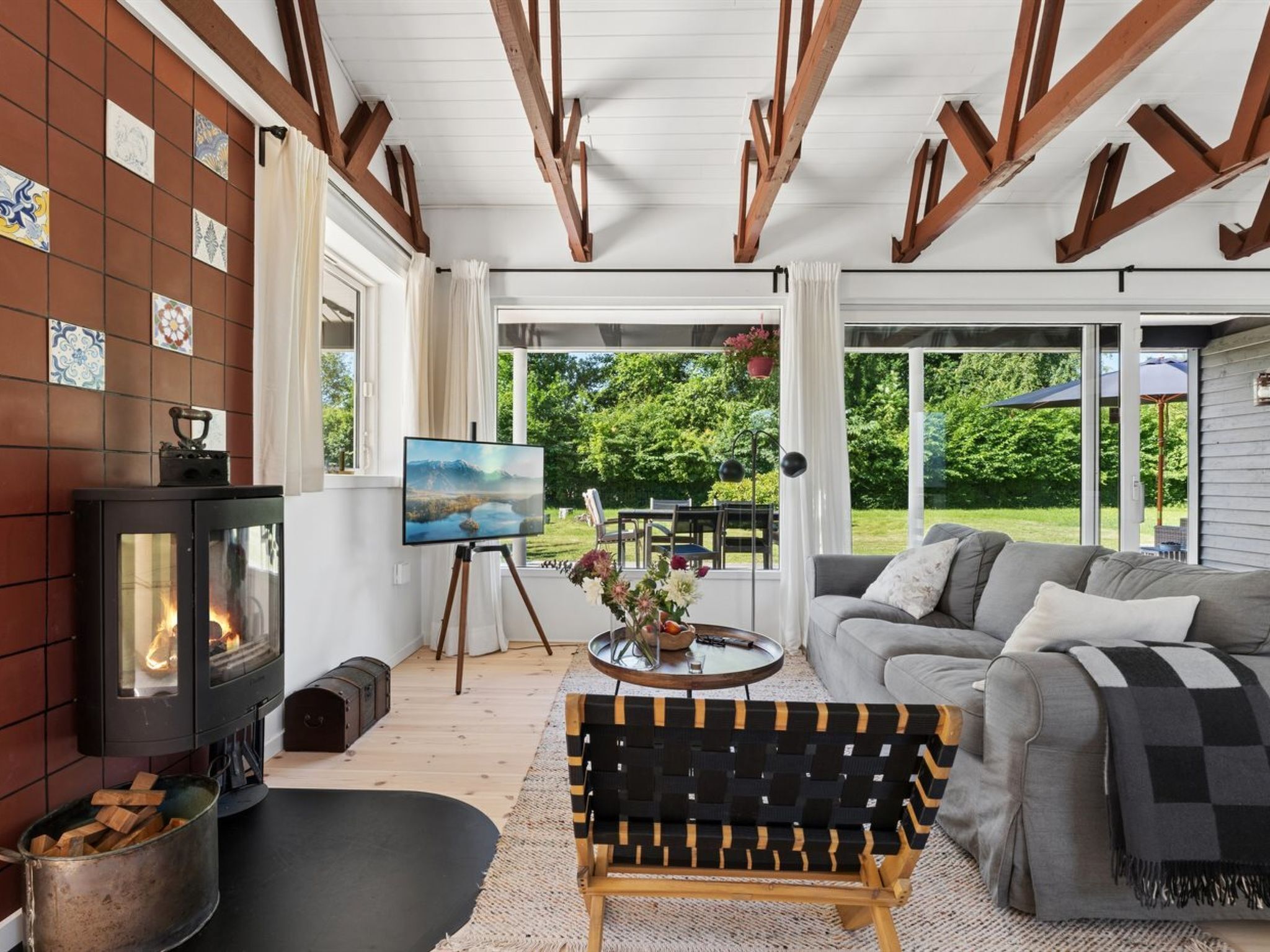 A cozy living room with a fireplace, a painting on easel, and a sofa.