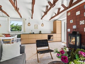 A modern kitchen with wooden beams, a dining area with a sofa, and a fireplace. - "Antonie" - 350m from the sea by Interhome (Vejby)