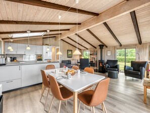 A spacious living area with a dining table, chairs, a sofa, and a fireplace. - "Clea" - 250m to the fjord by Interhome (Skjern)