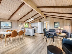 A spacious interior with a dining area, kitchen, and seating area, featuring wooden walls and ceiling beams. - "Clea" - 250m to the fjord by Interhome (Skjern)