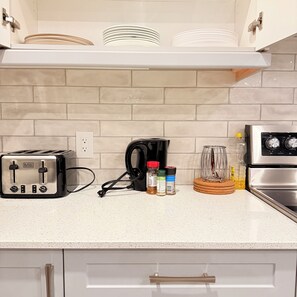A kitchen with a toaster, coffee maker, and spices on the counter. - Sleeps 16 and more | Bedrooms with ensuite washrooms (Springwater)