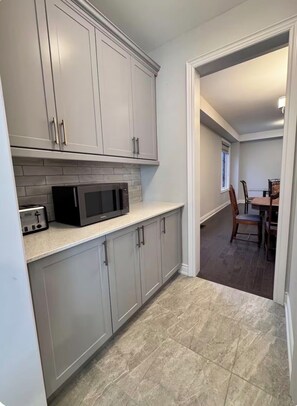 A kitchen with grey cabinets, a microwave, and a toaster. - Sleeps 16 and more | Bedrooms with ensuite washrooms (Springwater)