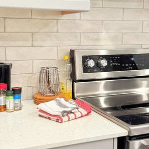 A kitchen with a stainless steel oven, a kettle, a bottle of oil, and various spices on the counter. - Sleeps 16 and more | Bedrooms with ensuite washrooms (Springwater)